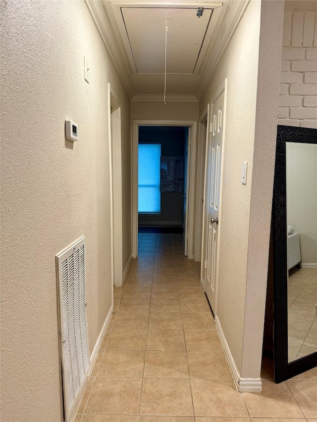 hallway with light tile patterned floors and crown molding