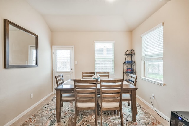 tiled dining room with lofted ceiling