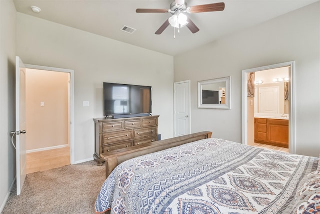 carpeted bedroom with ensuite bathroom and ceiling fan