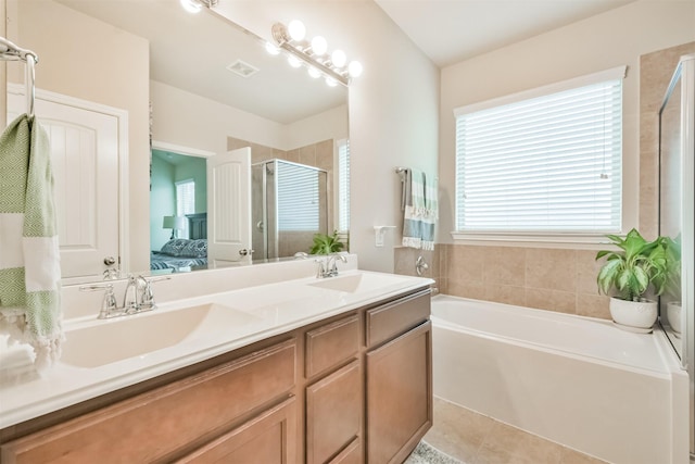 bathroom with tile patterned flooring, shower with separate bathtub, and vanity