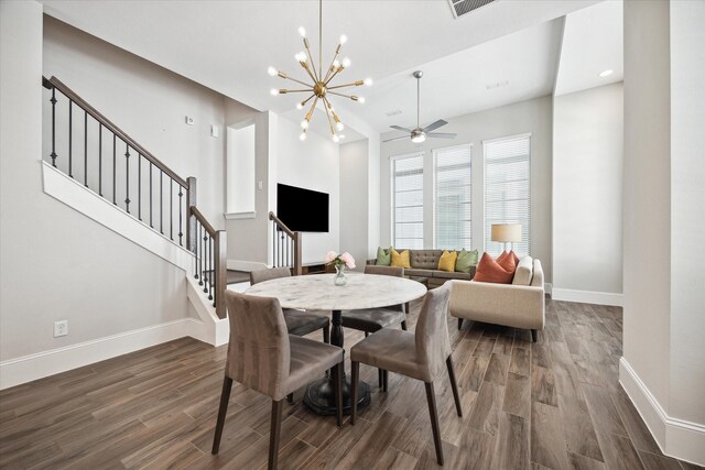 dining space featuring ceiling fan with notable chandelier and dark hardwood / wood-style flooring