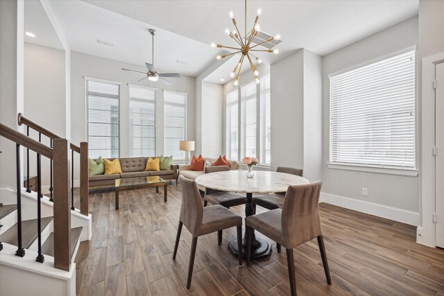 dining area featuring ceiling fan with notable chandelier