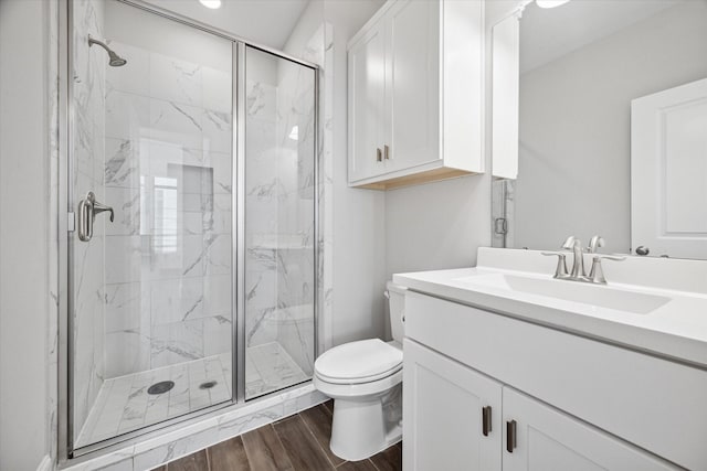 bathroom with walk in shower, vanity, and toilet