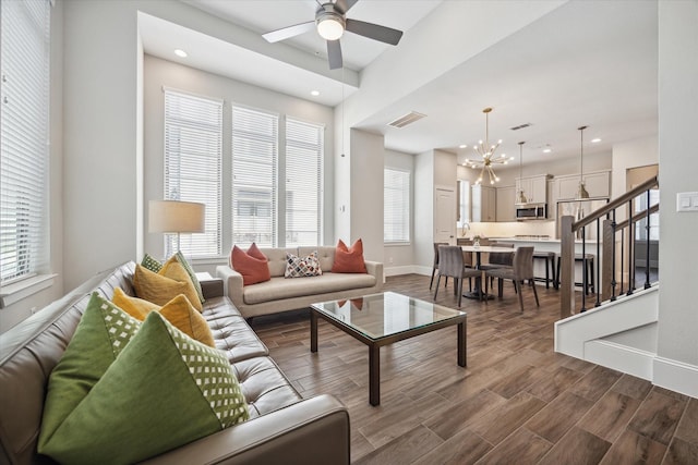 living room with ceiling fan with notable chandelier, a healthy amount of sunlight, and hardwood / wood-style floors