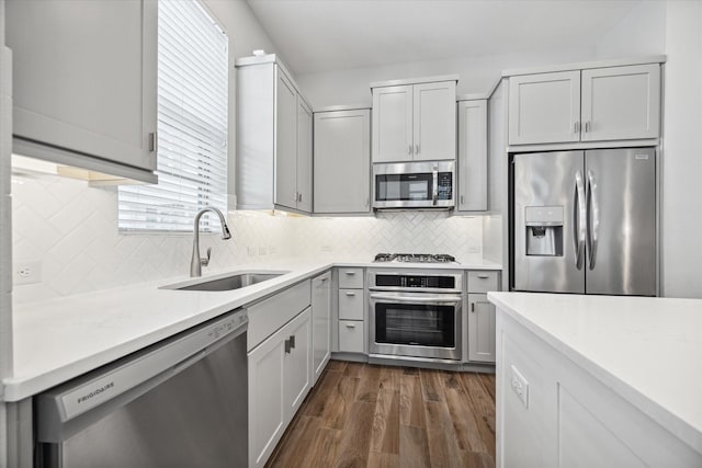 kitchen with decorative backsplash, stainless steel appliances, dark wood-type flooring, and sink