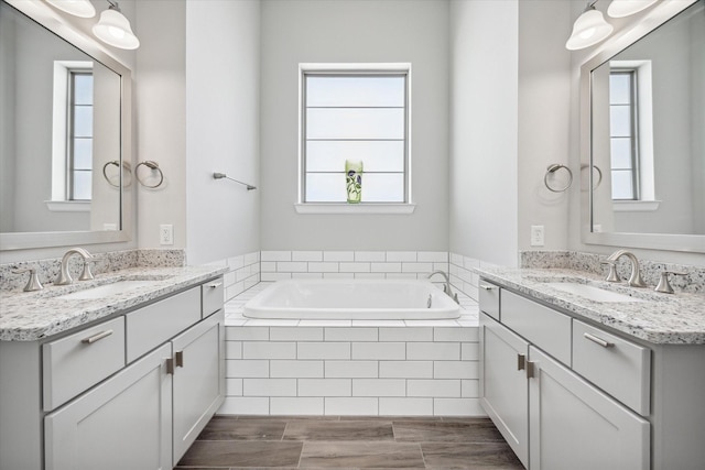 bathroom with vanity and a relaxing tiled tub