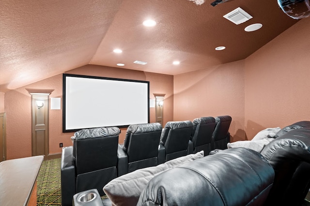 carpeted home theater featuring vaulted ceiling and a textured ceiling