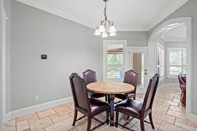 dining area with decorative columns, crown molding, and a notable chandelier