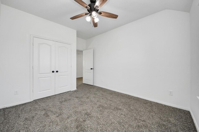 unfurnished bedroom with dark colored carpet, a closet, and ceiling fan