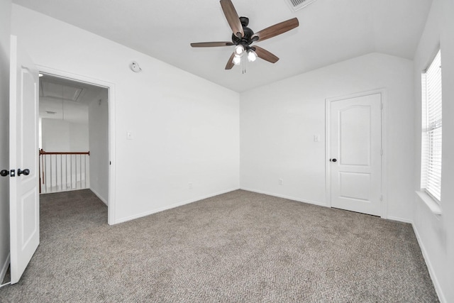 carpeted empty room featuring ceiling fan, a healthy amount of sunlight, and vaulted ceiling