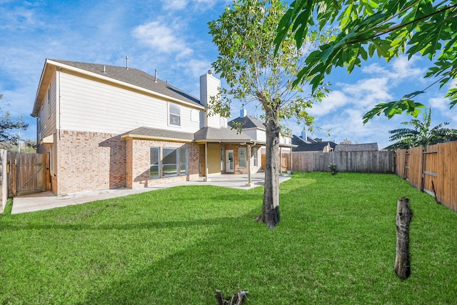 back of property with a lawn and a patio