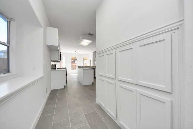 hall featuring light tile patterned floors