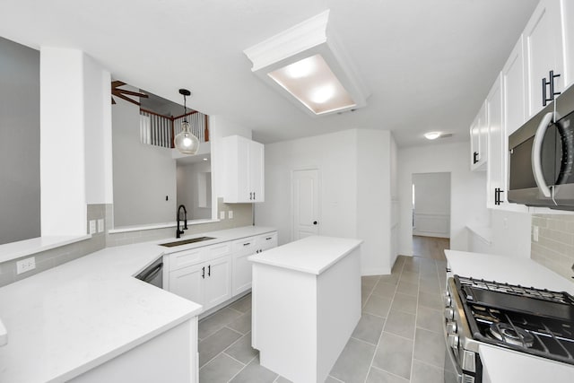 kitchen with pendant lighting, white cabinets, sink, kitchen peninsula, and stainless steel appliances