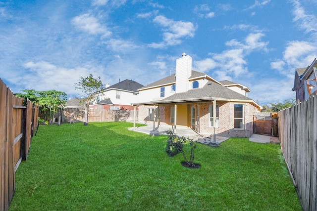 rear view of property with a yard and a patio