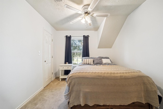 carpeted bedroom with ceiling fan and a textured ceiling