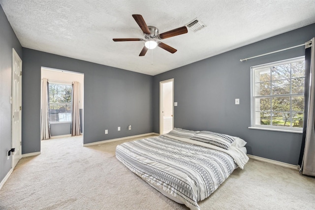 carpeted bedroom with a textured ceiling and ceiling fan