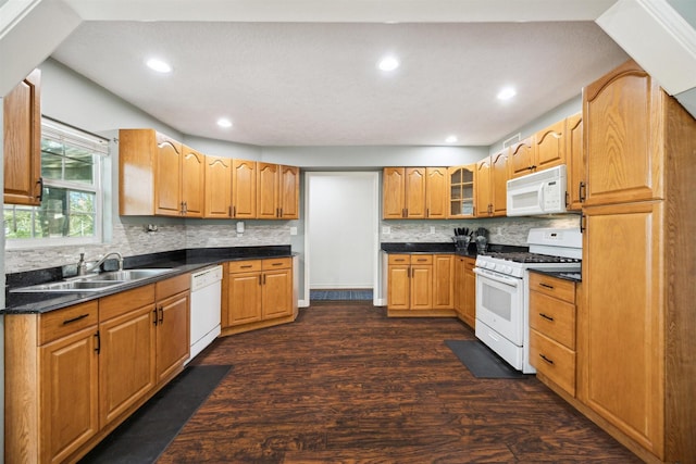 kitchen with dark hardwood / wood-style flooring, white appliances, sink, and tasteful backsplash