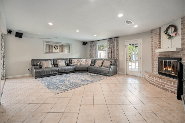 tiled living room featuring a brick fireplace