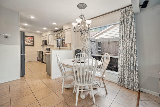 tiled dining room featuring sink and a chandelier