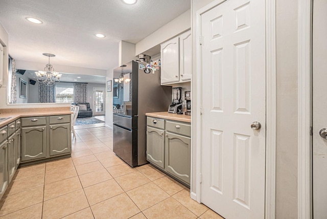 kitchen with an inviting chandelier, gray cabinets, light tile patterned flooring, and hanging light fixtures