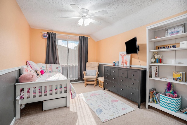 bedroom with lofted ceiling, a textured ceiling, ceiling fan, and carpet flooring