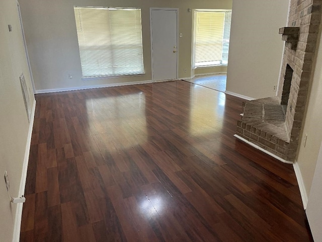 unfurnished living room featuring dark hardwood / wood-style floors and a fireplace