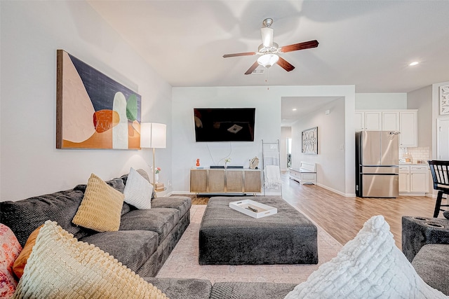 living room with ceiling fan and light hardwood / wood-style flooring