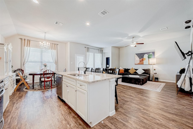 kitchen with sink, hanging light fixtures, stainless steel dishwasher, a kitchen island with sink, and white cabinets