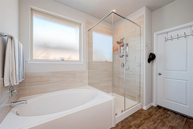 bathroom with hardwood / wood-style floors, plenty of natural light, and shower with separate bathtub