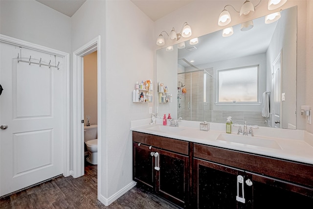 bathroom featuring hardwood / wood-style floors, vanity, an enclosed shower, and toilet