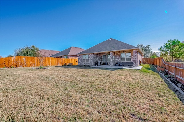 rear view of house featuring a lawn and a patio