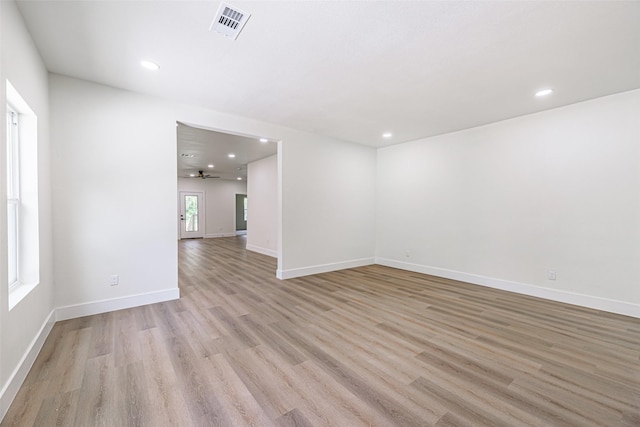 empty room with ceiling fan and light hardwood / wood-style floors