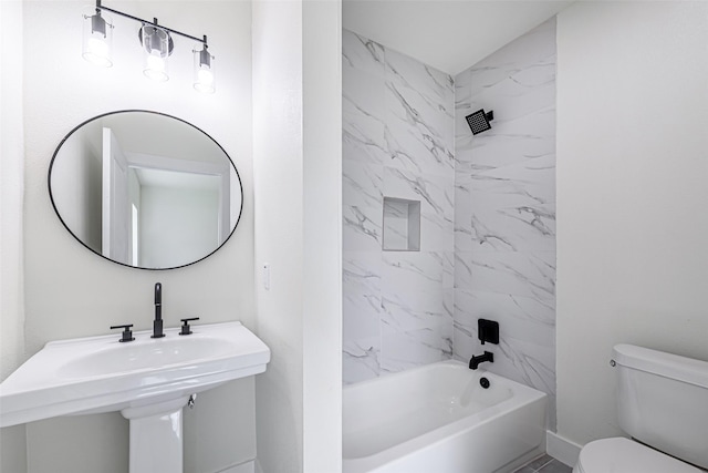 full bathroom with tiled shower / bath combo, toilet, and sink