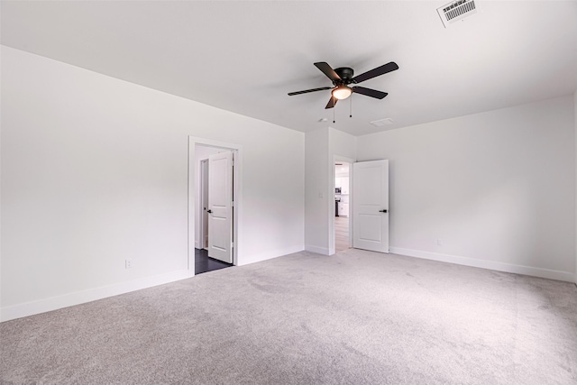 spare room featuring ceiling fan and dark carpet