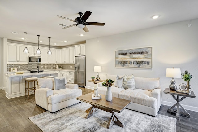 living room with ceiling fan and sink