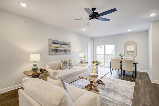 living room featuring ceiling fan and dark wood-type flooring