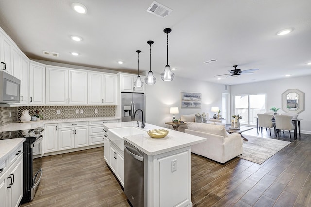 kitchen featuring a kitchen island with sink, sink, white cabinets, and appliances with stainless steel finishes