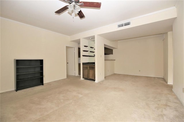 unfurnished living room with light colored carpet, ceiling fan, and crown molding