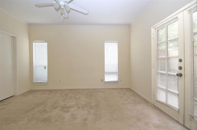 unfurnished room with ceiling fan, ornamental molding, and light carpet