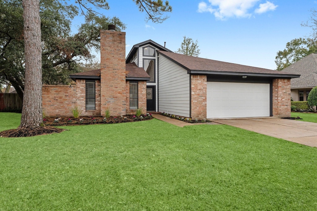 view of front of home with a garage and a front lawn