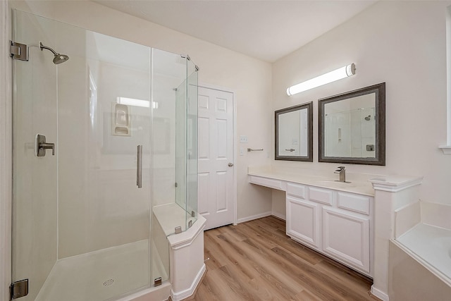 bathroom with hardwood / wood-style floors, vanity, and plus walk in shower