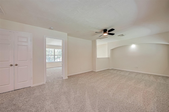 empty room with ceiling fan, carpet, and a textured ceiling