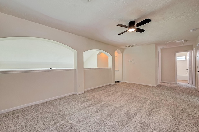 carpeted spare room with ceiling fan and a textured ceiling