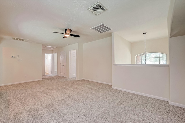 carpeted spare room featuring a textured ceiling and ceiling fan