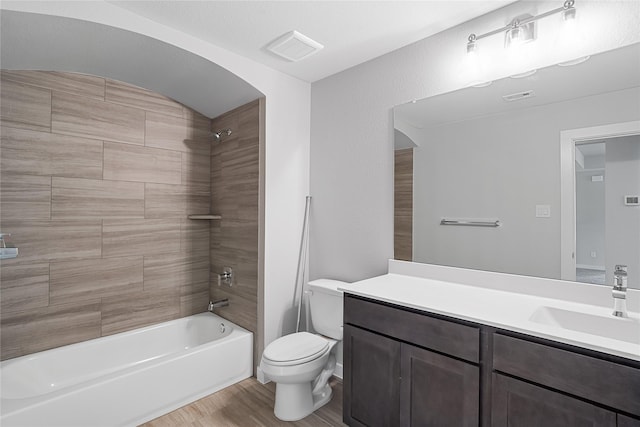 full bathroom with hardwood / wood-style floors, vanity, toilet, and tiled shower / bath