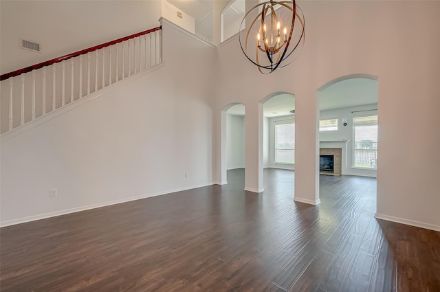 interior space with a notable chandelier, dark wood-type flooring, and a high ceiling