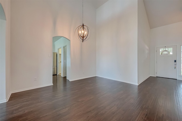 interior space with dark hardwood / wood-style flooring, high vaulted ceiling, and an inviting chandelier