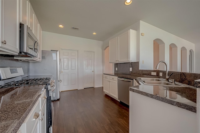 kitchen featuring sink, dark hardwood / wood-style floors, kitchen peninsula, white cabinets, and appliances with stainless steel finishes