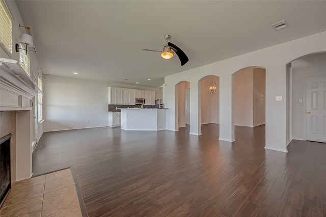 unfurnished living room featuring wood-type flooring and ceiling fan