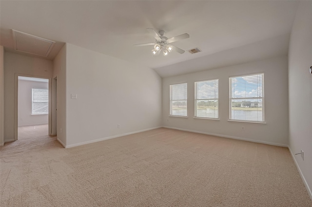 empty room with ceiling fan, light colored carpet, and vaulted ceiling